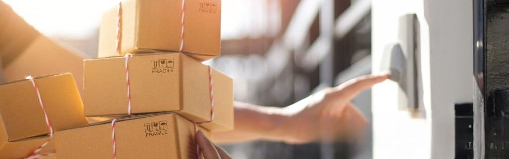 Delivery man holding parcel boxes and ring the doorbell on the client's door in the morning background.